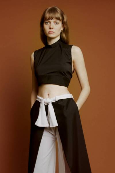createur mode design paris brassière noire nouable dans le dos. utilisation de tissu microfibre noir. pantalon à pans noir et blanc à ceinture nouable. les pans peuvent êtres relevés puis noués pour ainsi former une combinaison. utilisation de tissus microfibre noir et blanc.