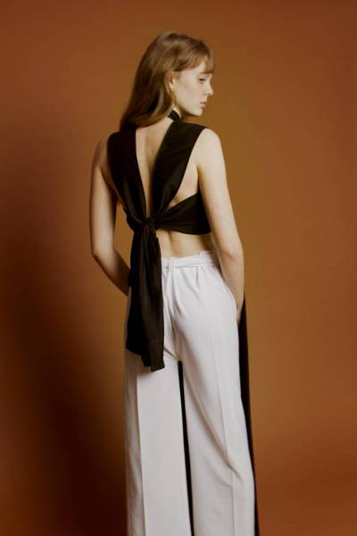 createur mode design paris brassière noire nouable dans le dos. utilisation de tissu microfibre noir. pantalon à pans noir et blanc à ceinture nouable. les pans peuvent êtres relevés puis noués pour ainsi former une combinaison. utilisation de tissus microfibre noir et blanc.