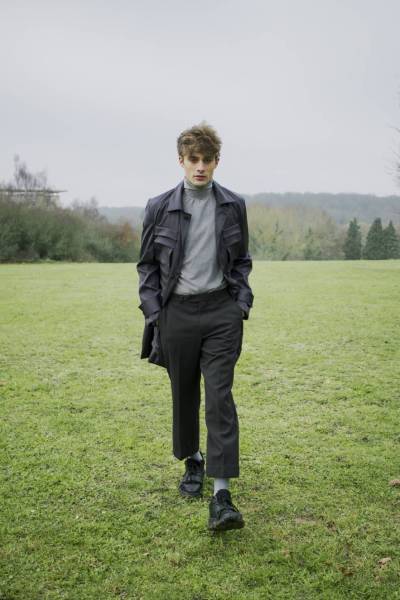 createur mode design paris gabardine anthracite à poches. utilisation de tissu gabardine anthracite. pull à col montant gris. utilisation de jersey gris. pantalon droit noir à fines rayures. utilisation de gabardine de coton.