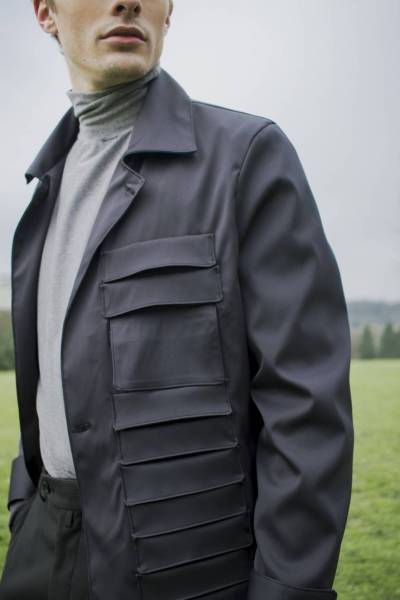 createur mode design paris gabardine anthracite à poches. utilisation de tissu gabardine anthracite. pull à col montant gris. utilisation de jersey gris. pantalon droit noir à fines rayures. utilisation de gabardine de coton.